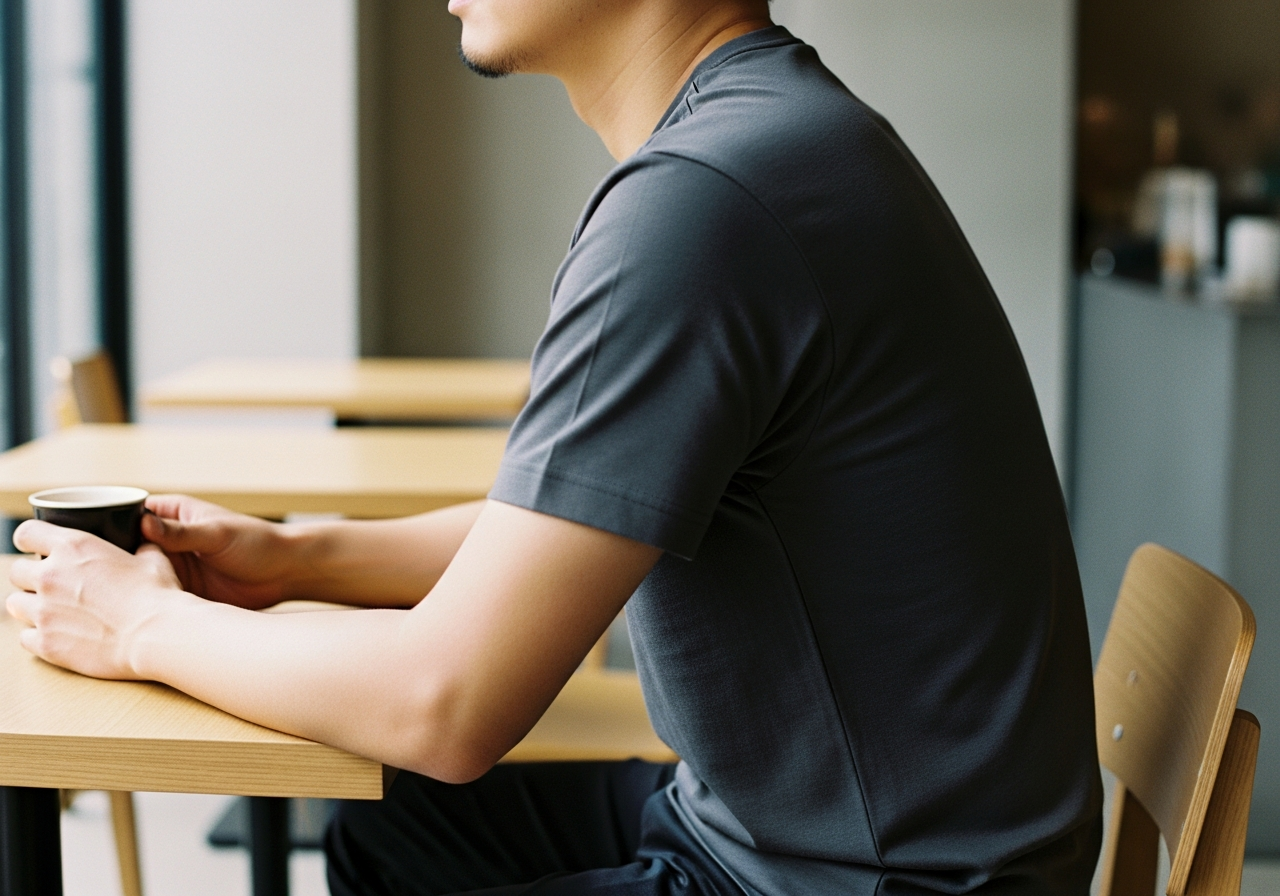 都会のカフェでUniqlo UのTシャツを着る男性の後ろ姿